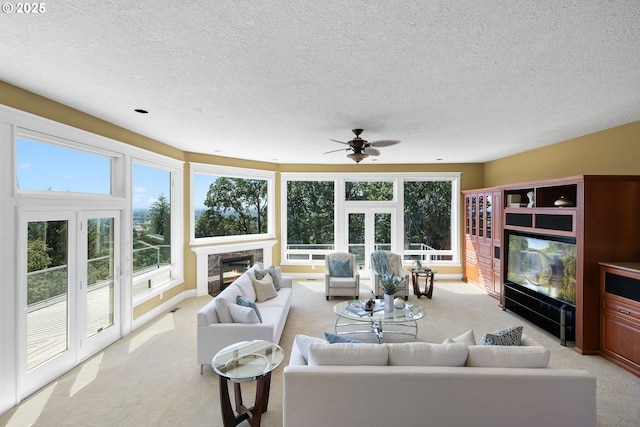 16155 NE Wilkerson Way, Newberg, OR 97132 - living room with a fireplace, ceiling fan, light carpet, and a textured ceiling