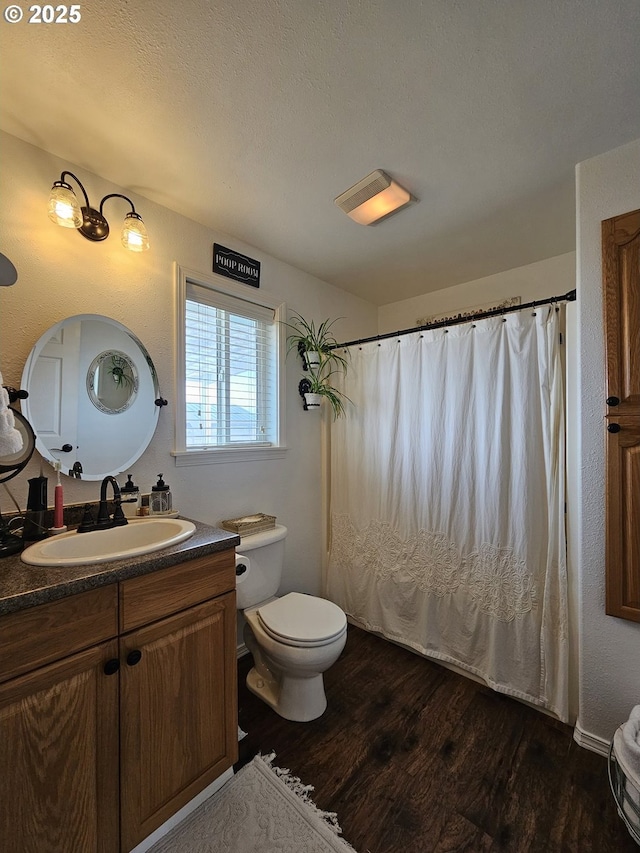 bathroom with toilet, vanity, a textured ceiling, and hardwood / wood-style floors