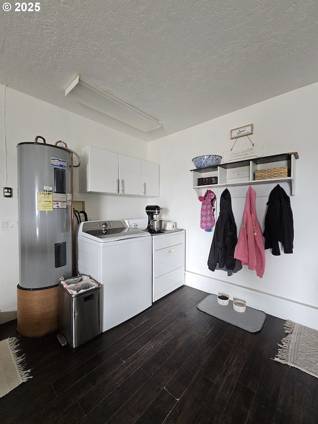 washroom with a textured ceiling, cabinets, electric water heater, dark hardwood / wood-style flooring, and washing machine and clothes dryer