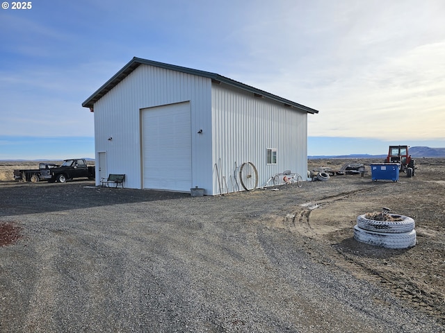 view of outdoor structure featuring a mountain view, an outdoor fire pit, and a garage