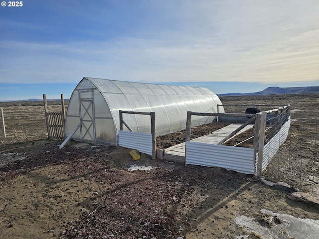 view of outbuilding with a rural view and a mountain view