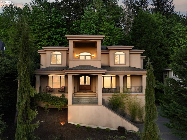 view of front of house with stucco siding, a porch, french doors, and stairs