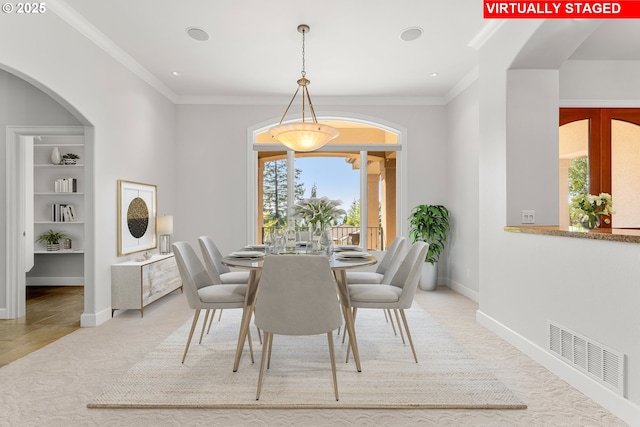 370 NW 81st Pl, Portland, OR 97229 - dining area featuring built in features, crown molding, baseboards, arched walkways, and light colored carpet