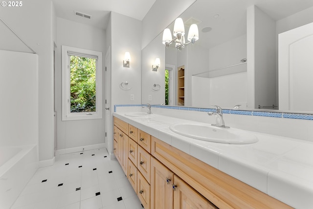 370 NW 81st Pl, Portland, OR 97229 - full bathroom featuring double vanity, tile patterned floors, baseboards, and a chandelier