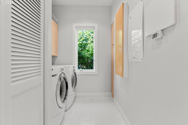 370 NW 81st Pl, Portland, OR 97229 - laundry area with cabinet space, washer and clothes dryer, light tile patterned floors, and baseboards