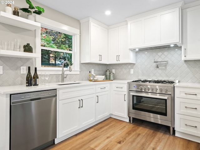 5325 NE Flanders St, Portland, OR 97213 - kitchen with stainless steel appliances, a sink, light countertops, white cabinetry, and recessed lighting