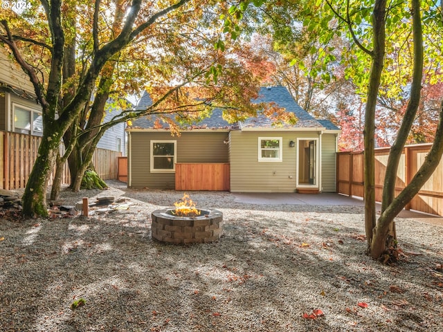 5325 NE Flanders St, Portland, OR 97213 - rear view of house featuring a fire pit, a patio, a fenced backyard, and a shingled roof