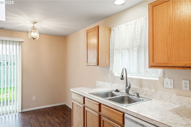 kitchen featuring dark wood-type flooring, baseboards, light countertops, white dishwasher, and a sink