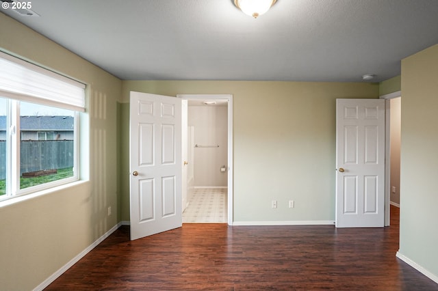 unfurnished bedroom featuring dark wood-type flooring and baseboards