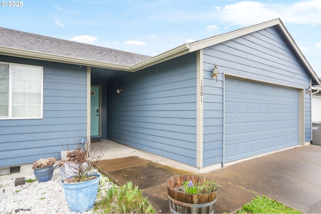 entrance to property featuring a garage and roof with shingles