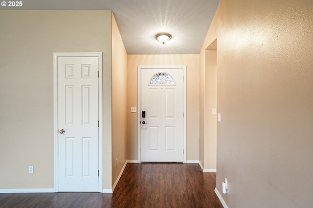 entryway with dark wood finished floors and baseboards