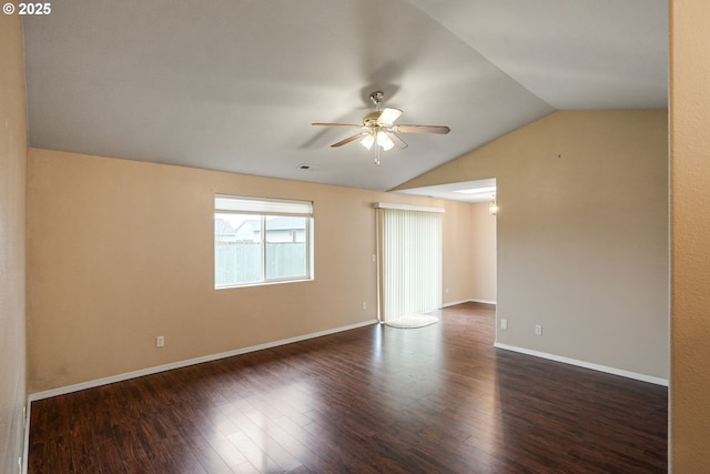 empty room featuring dark wood-style floors, visible vents, baseboards, ceiling fan, and vaulted ceiling