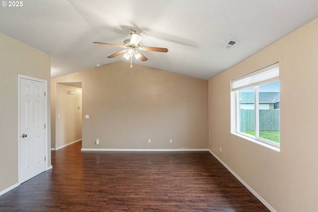 spare room featuring baseboards, visible vents, dark wood finished floors, lofted ceiling, and ceiling fan