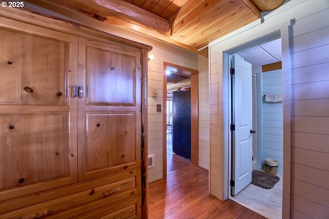 corridor with wood walls, visible vents, wood ceiling, and wood finished floors