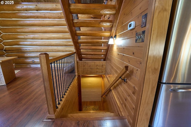 stairway featuring log walls and wood-type flooring
