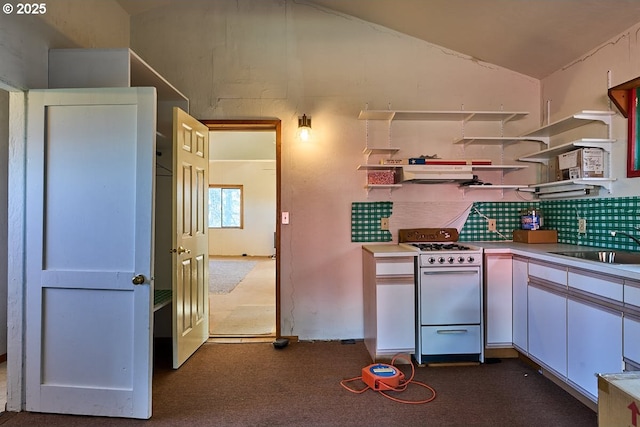 kitchen featuring vaulted ceiling, open shelves, white gas range, backsplash, and dark colored carpet
