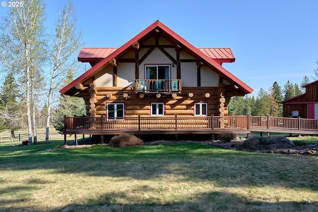 rear view of property with metal roof, log siding, and a lawn