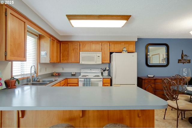 5219 Lacey Ct N, Keizer, OR 97303 - kitchen with a peninsula, a sink, a kitchen bar, white appliances, and light countertops