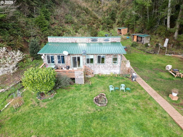 83126 Siltcoos Station Rd, Westlake, OR 97493 - view of front facade with a wooden deck, a front yard, an outdoor fire pit, and a metal roof