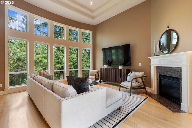 13581 SW Essex Dr, Portland, OR 97223 - living room featuring healthy amount of natural light, a towering ceiling, light wood-type flooring, a fireplace with flush hearth, and recessed lighting