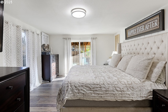 bedroom featuring access to outside and dark wood-style flooring