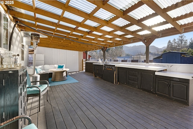 wooden terrace featuring a storage shed, an outdoor structure, a mountain view, and outdoor lounge area