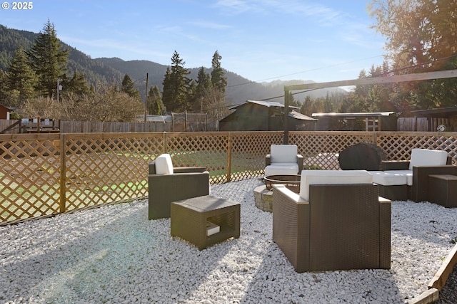 view of patio featuring grilling area, a mountain view, a fire pit, and fence