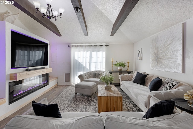 living area with a chandelier, a textured ceiling, wood finished floors, and vaulted ceiling with beams