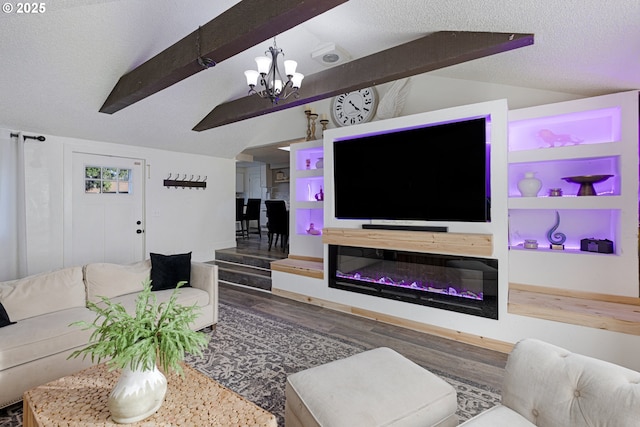 living area with built in shelves, a notable chandelier, a textured ceiling, wood finished floors, and vaulted ceiling with beams