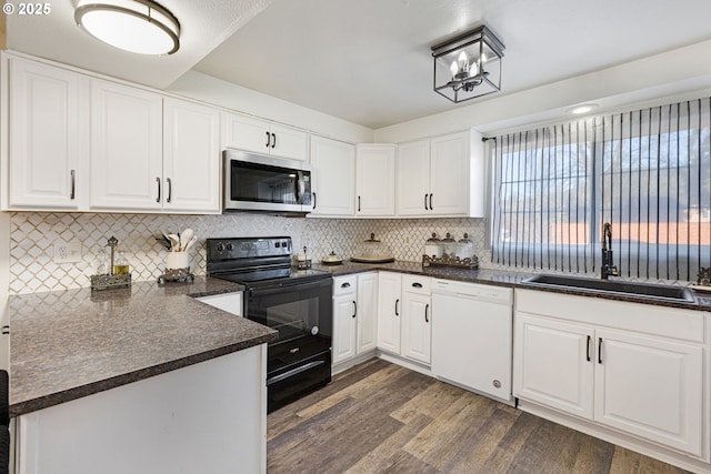 kitchen featuring electric range, a sink, stainless steel microwave, dark countertops, and dishwasher