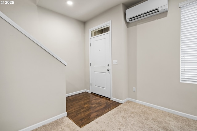 entryway featuring a wall mounted AC and dark carpet