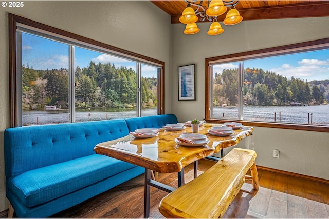 70202 Potato Bottom Rd, Lakeside, OR 97449 - dining area with hardwood / wood-style floors, a chandelier, wood ceiling with exposed beams, baseboards, and a water view