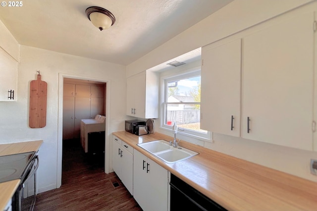 755 NE Ochoco Ave, Prineville, OR 97754 - kitchen with dark wood-style flooring, a sink, light countertops, white cabinetry, and black appliances
