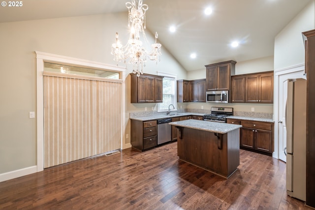 kitchen featuring dark brown cabinetry, a kitchen island, dark wood-style flooring, stainless steel appliances, and a sink