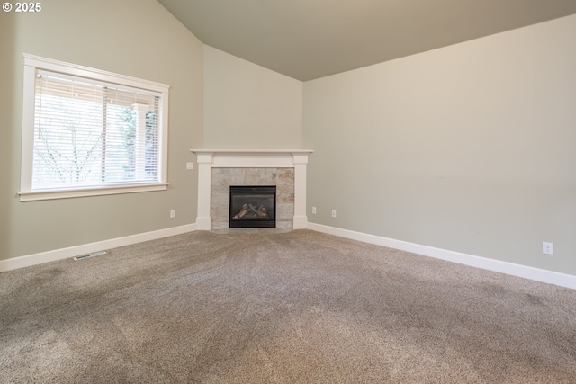 unfurnished living room with vaulted ceiling, carpet floors, a fireplace, and baseboards