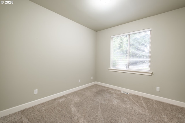 unfurnished room with light colored carpet, visible vents, and baseboards