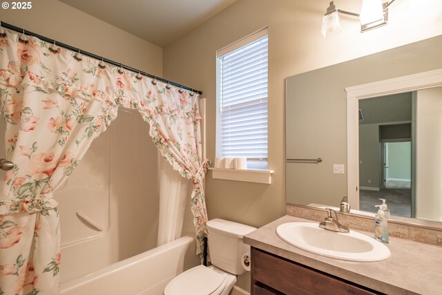 full bath featuring toilet, plenty of natural light, shower / bath combo with shower curtain, and vanity