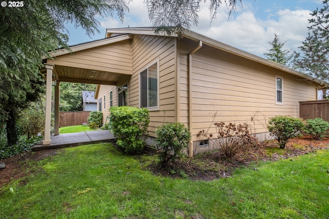 view of side of property featuring crawl space, fence, and a lawn