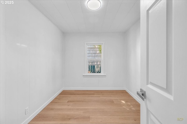 empty room featuring baseboards and light wood-style flooring