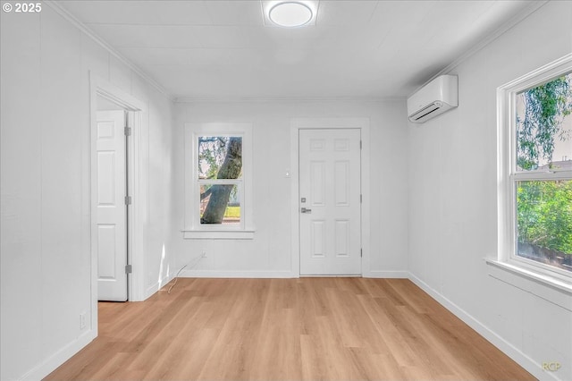 unfurnished room with a healthy amount of sunlight, an AC wall unit, and light wood-style flooring
