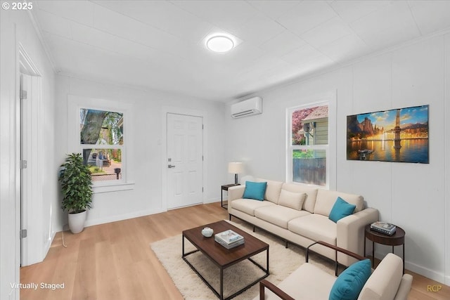 living area with baseboards, light wood finished floors, a wall mounted air conditioner, and a wealth of natural light