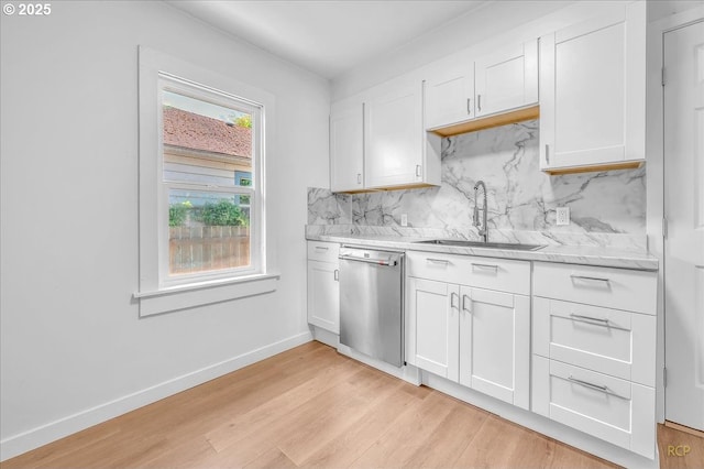 kitchen featuring a sink, white cabinetry, backsplash, and dishwasher