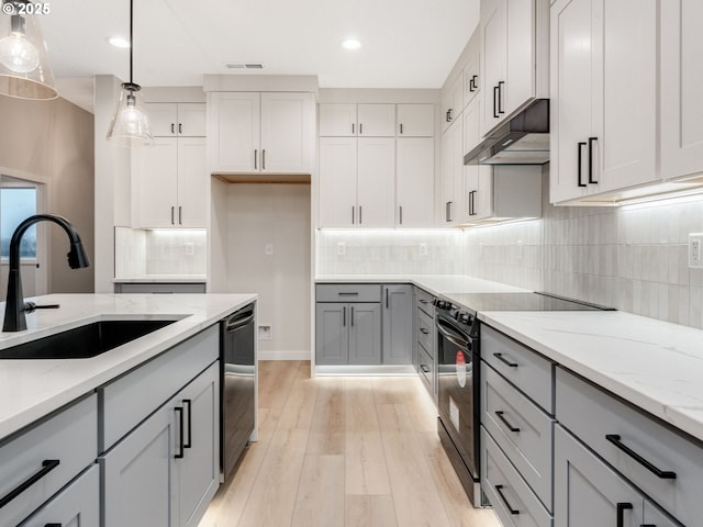 kitchen featuring gray cabinets, pendant lighting, sink, light stone counters, and black appliances