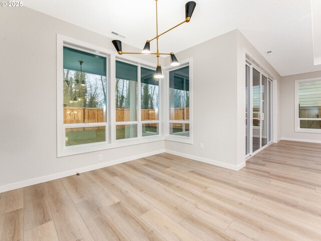 interior space with baseboards, visible vents, and light wood finished floors