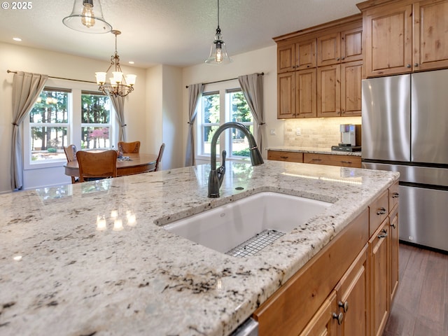 36280 SE Hauglum Rd, Boring, OR 97009 - kitchen with freestanding refrigerator, light stone countertops, wood finished floors, decorative backsplash, and recessed lighting