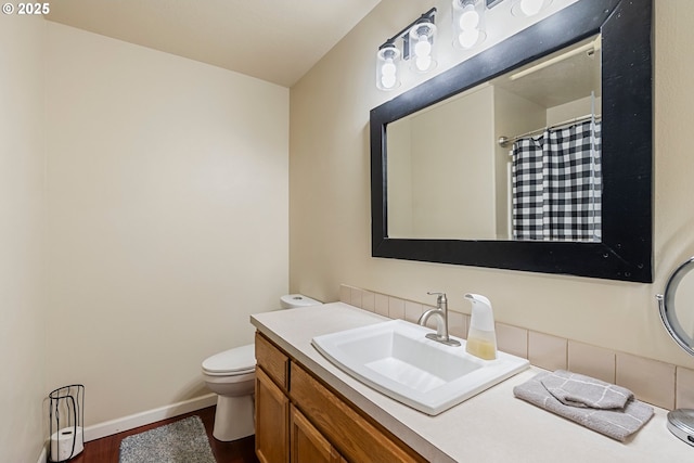 bathroom with toilet, wood finished floors, baseboards, vanity, and a shower with curtain