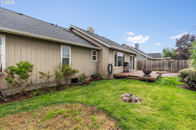 back of property featuring a deck, a shingled roof, and a chimney