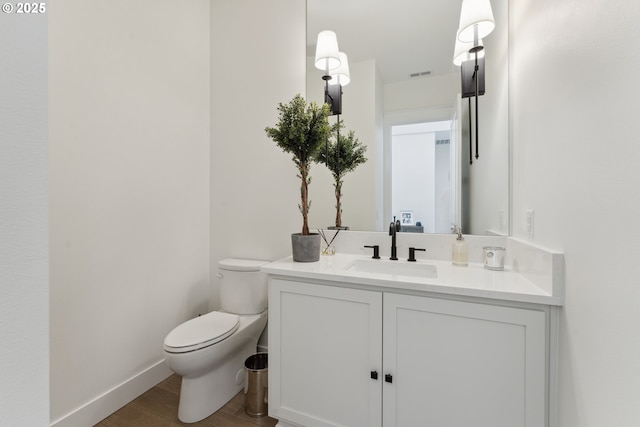 bathroom featuring hardwood / wood-style flooring, vanity, and toilet