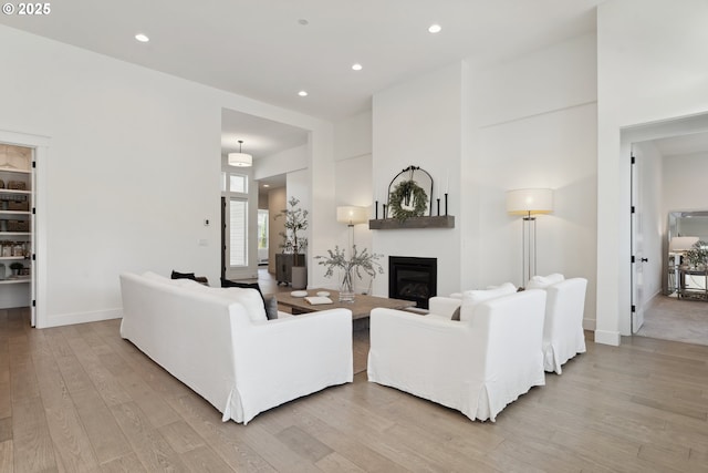 living room with a large fireplace and light wood-type flooring