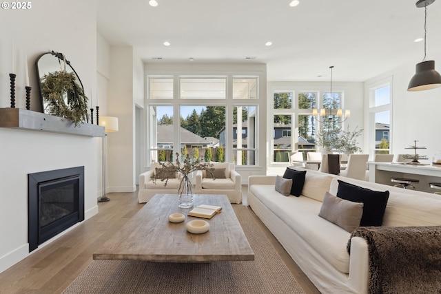 living room featuring a chandelier and light wood-type flooring